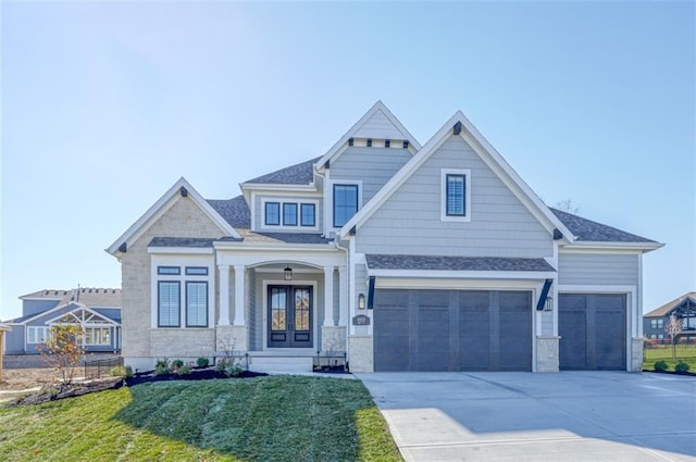 craftsman-style home featuring french doors, a garage, and a front lawn