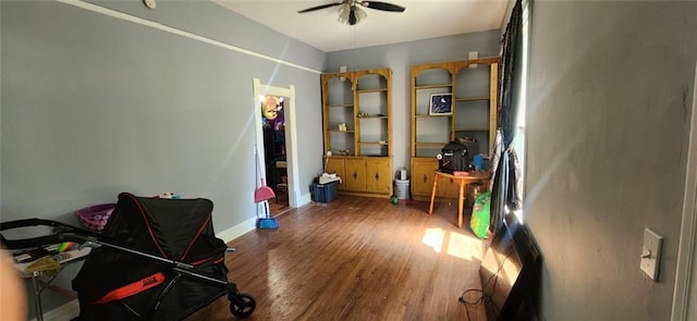 miscellaneous room with ceiling fan and dark hardwood / wood-style flooring