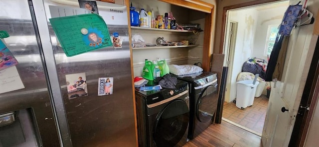 clothes washing area featuring washer and dryer and hardwood / wood-style flooring