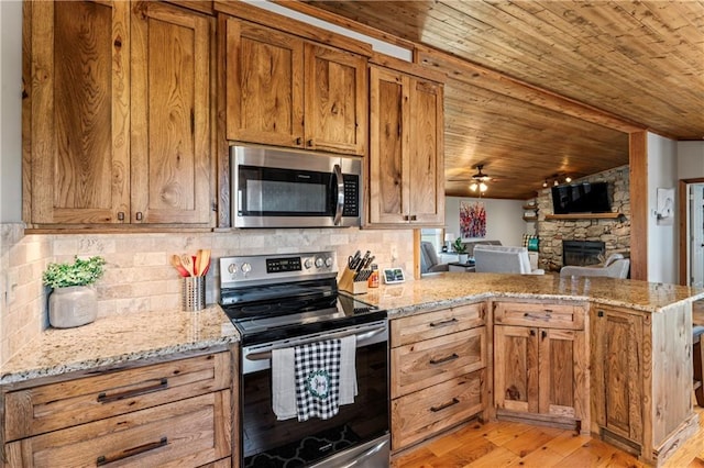 kitchen with wood ceiling, backsplash, stainless steel appliances, light stone counters, and kitchen peninsula