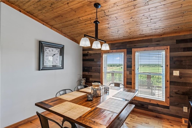 dining space featuring lofted ceiling, wood ceiling, wooden walls, and light wood-type flooring