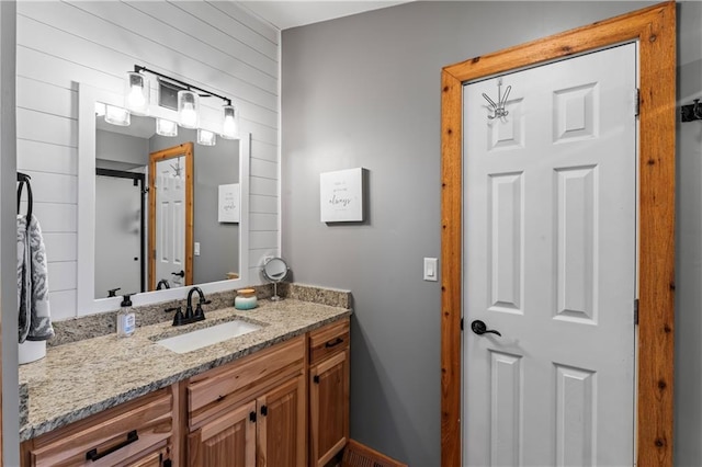 bathroom featuring vanity and wood walls