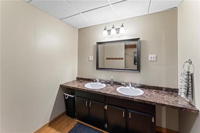 bathroom featuring vanity, hardwood / wood-style floors, and a drop ceiling