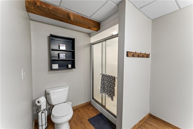 bathroom featuring a shower with door, wood-type flooring, a paneled ceiling, and toilet