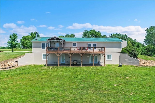 back of property featuring a lawn, a deck, and a patio area