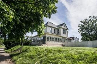 rear view of property featuring a sunroom