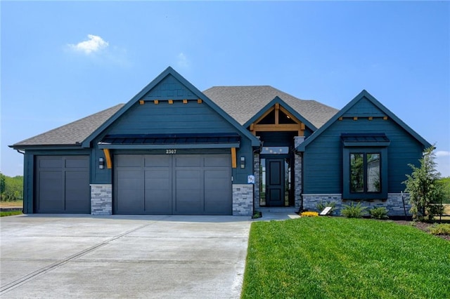 craftsman-style house with concrete driveway, stone siding, an attached garage, and a front yard
