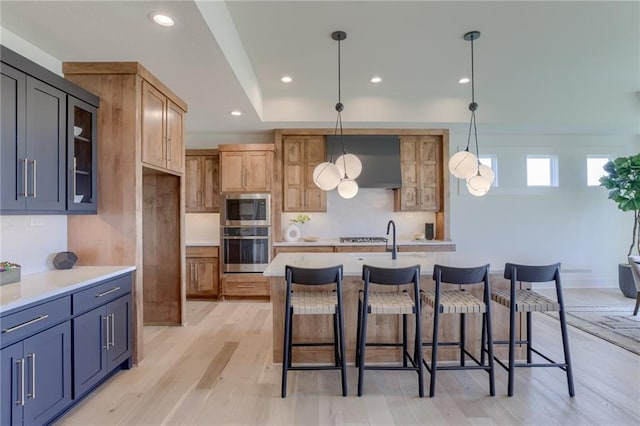 kitchen with glass insert cabinets, a kitchen breakfast bar, stainless steel microwave, light countertops, and recessed lighting