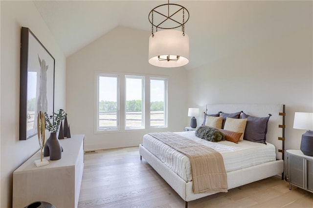 bedroom with lofted ceiling and light wood-style flooring