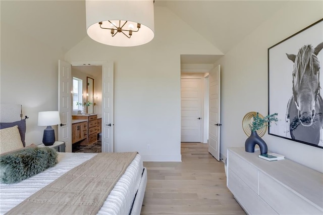 bedroom with a notable chandelier, light wood-style flooring, baseboards, connected bathroom, and high vaulted ceiling