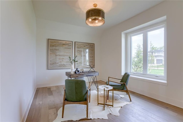 sitting room with baseboards and hardwood / wood-style flooring