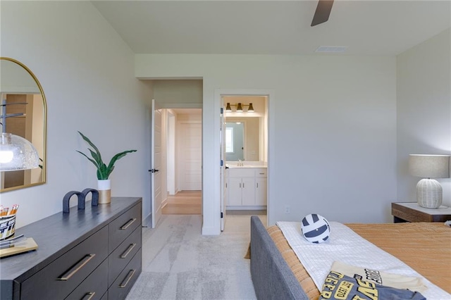 bedroom featuring a sink, light colored carpet, visible vents, a ceiling fan, and connected bathroom