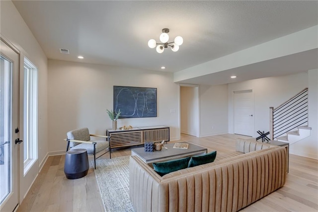 living area with visible vents, recessed lighting, stairway, light wood finished floors, and baseboards