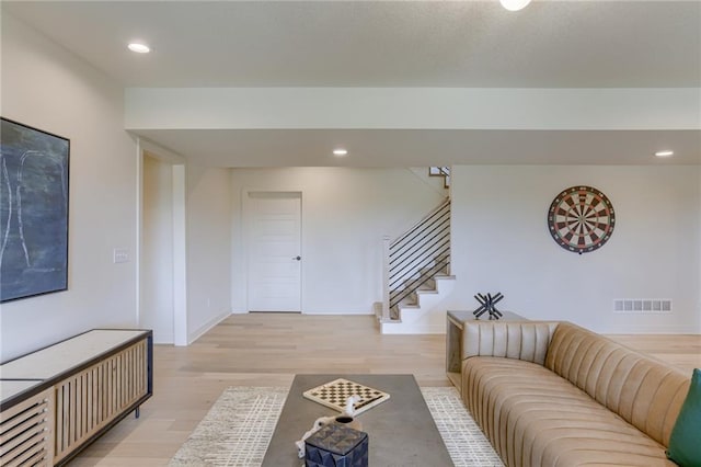 living room featuring recessed lighting, baseboards, visible vents, stairs, and light wood-type flooring