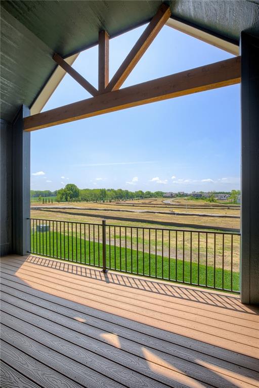 wooden terrace with a rural view and a yard