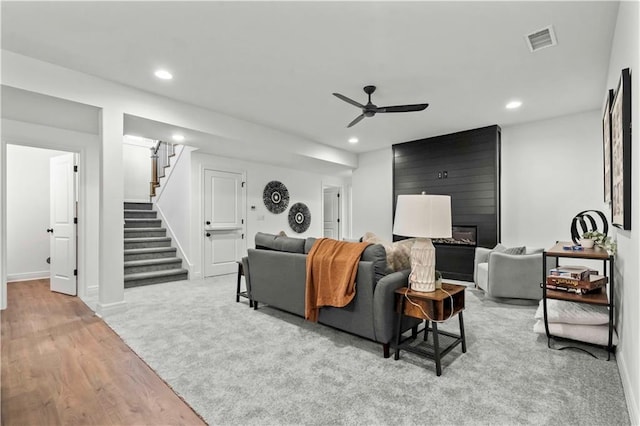 carpeted living room featuring ceiling fan