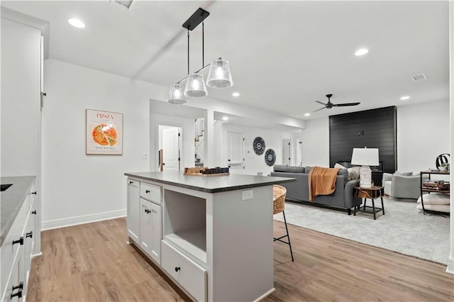 1600 SW 27th St, Lees Summit, MO 64082 - kitchen with a ceiling fan, dark countertops, a kitchen bar, white cabinetry, and light wood-style floors