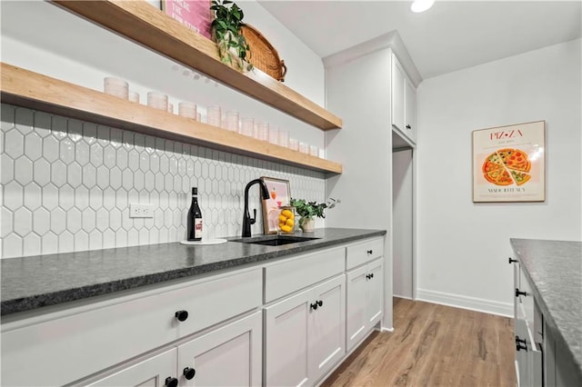 1600 SW 27th St, Lees Summit, MO 64082 - kitchen featuring open shelves, a sink, decorative backsplash, light wood-type flooring, and white cabinets