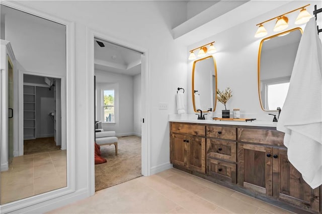 1600 SW 27th St, Lees Summit, MO 64082 - bathroom with double vanity, a spacious closet, baseboards, and tile patterned floors