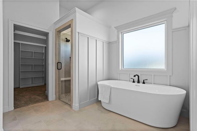 bathroom with built in features and separate shower and tub