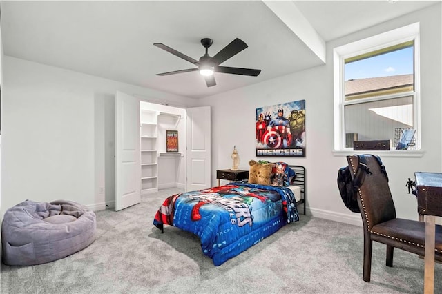 bedroom with ceiling fan, a spacious closet, and light colored carpet