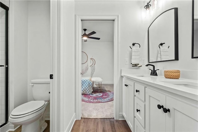 1600 SW 27th St, Lees Summit, MO 64082 - bathroom featuring double vanity, toilet, wood finished floors, ceiling fan, and an enclosed shower