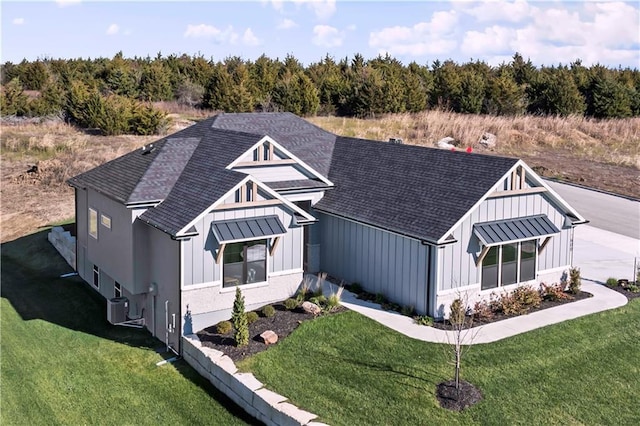 1600 SW 27th St, Lees Summit, MO 64082 - view of front of home with board and batten siding, roof with shingles, a front lawn, and central AC