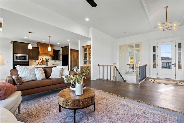 living room with sink, an inviting chandelier, and dark wood-type flooring