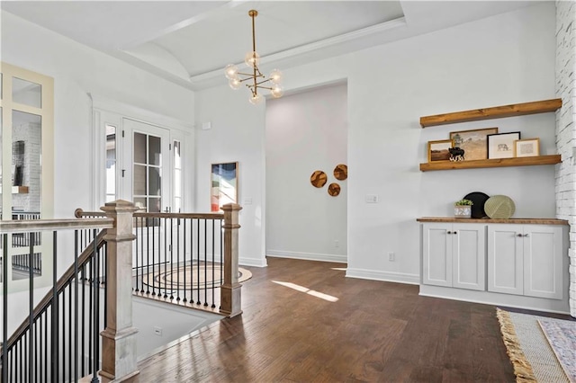 hall with dark hardwood / wood-style flooring and an inviting chandelier