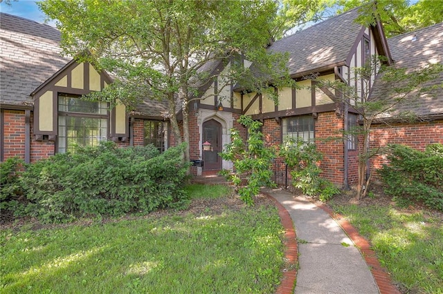 tudor-style house featuring a front lawn