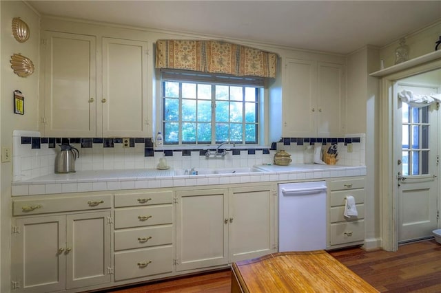 kitchen with decorative backsplash, sink, dark wood-type flooring, and tile counters