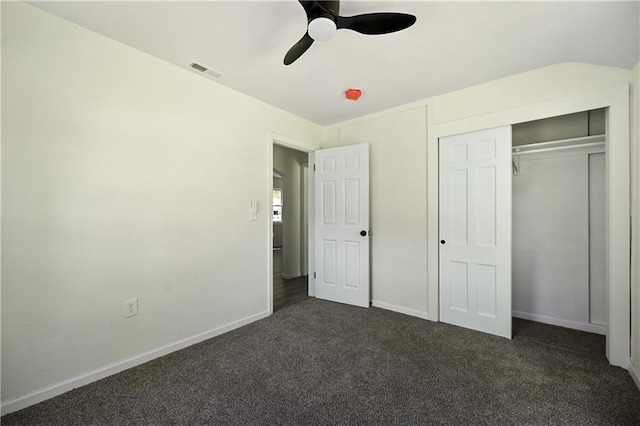 unfurnished bedroom with ceiling fan, a closet, and dark carpet