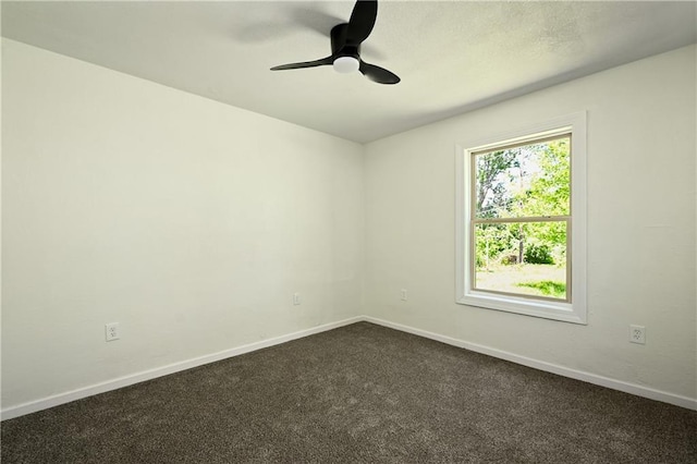 unfurnished room featuring ceiling fan and dark carpet