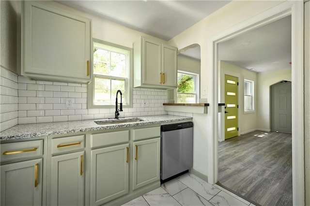 kitchen with decorative backsplash, a wealth of natural light, dishwasher, and sink