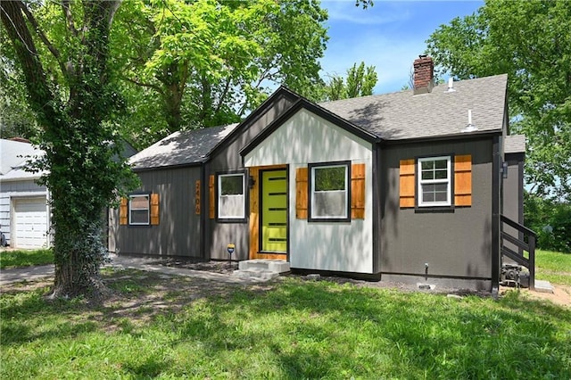 view of front of property with a garage and a front lawn