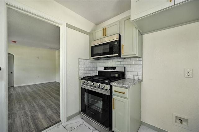 kitchen featuring light wood-type flooring, appliances with stainless steel finishes, and backsplash