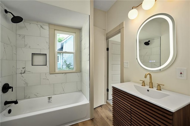 bathroom featuring hardwood / wood-style floors, vanity, and tiled shower / bath