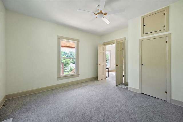 spare room with ceiling fan and light colored carpet