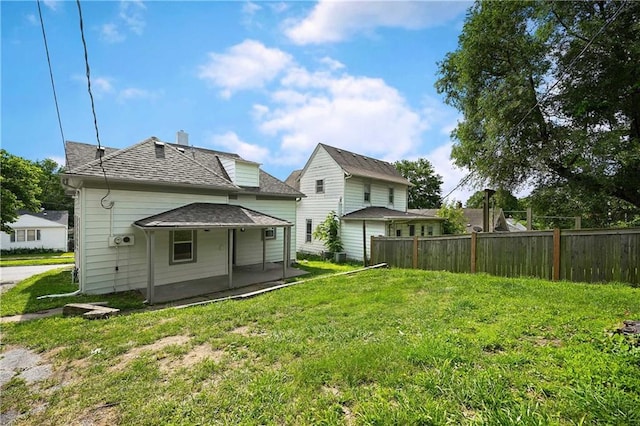 rear view of house featuring a yard and a patio