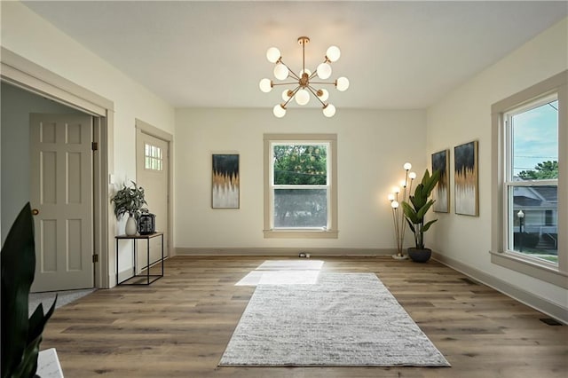 interior space with light wood-type flooring and an inviting chandelier