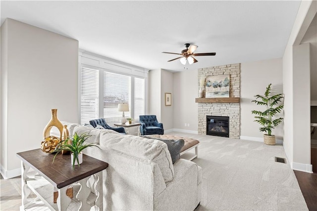 living room with ceiling fan, wood-type flooring, and a fireplace