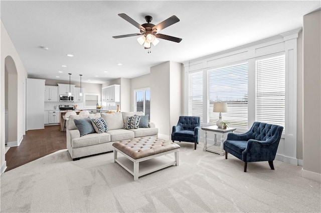 living room featuring ceiling fan and light colored carpet