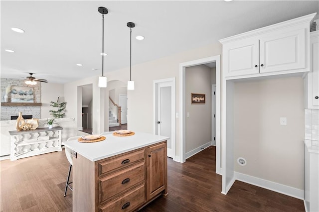 kitchen featuring a kitchen island, dark hardwood / wood-style floors, white cabinets, and decorative light fixtures