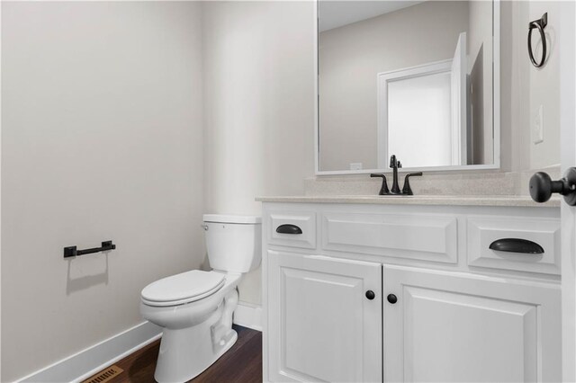 bathroom featuring vanity, toilet, and hardwood / wood-style floors