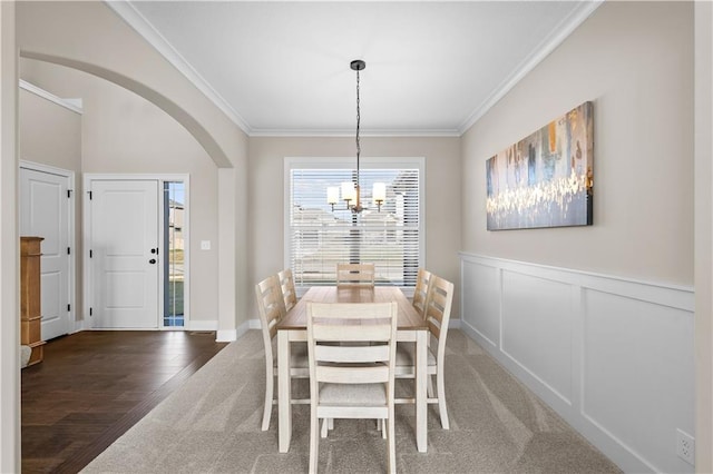 dining area featuring crown molding, dark hardwood / wood-style floors, and an inviting chandelier