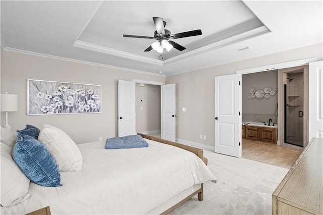 bedroom with light tile patterned floors, ceiling fan, connected bathroom, a tray ceiling, and ornamental molding