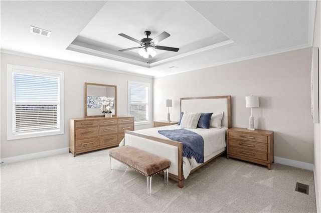 carpeted bedroom featuring a tray ceiling and ceiling fan