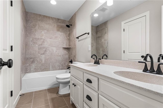 full bathroom with tile patterned floors, vanity, toilet, and tiled shower / bath combo