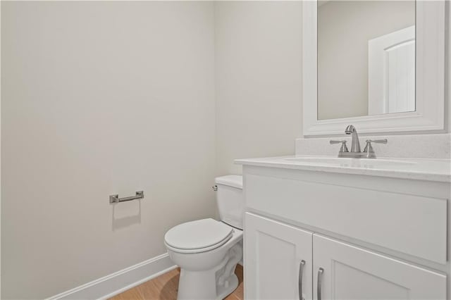 bathroom featuring hardwood / wood-style floors, vanity, and toilet