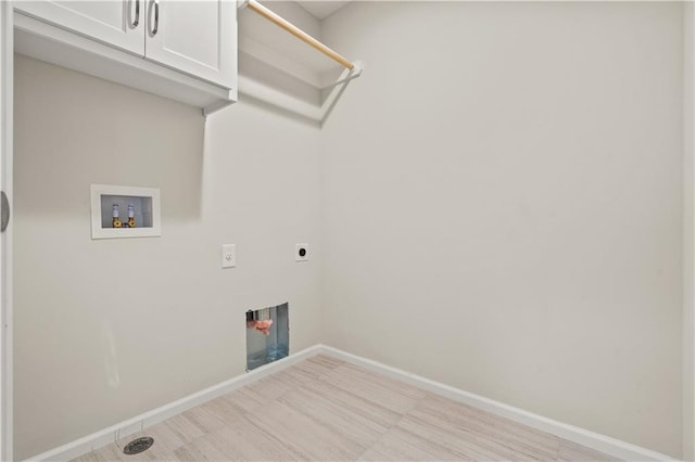 laundry room featuring electric dryer hookup, a fireplace, hookup for a washing machine, and cabinets